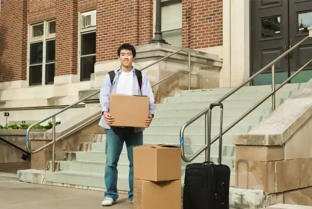 student holding boxes waiting for an expert local student mover
